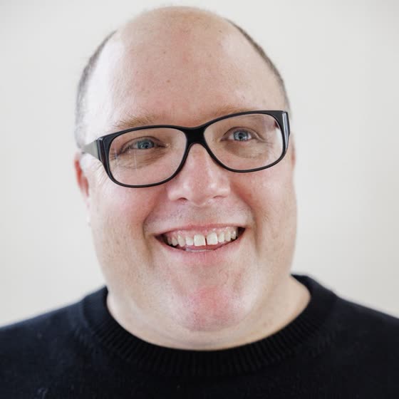 Chris Bruce, smiling, in a black sweater